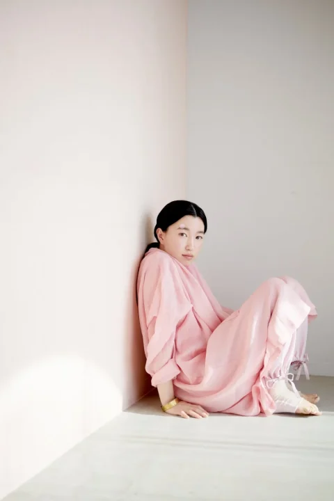 ピンクのゆったりとした服をまとった女性