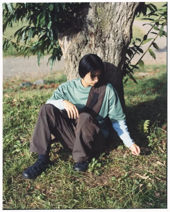 木にもたれて座る人物