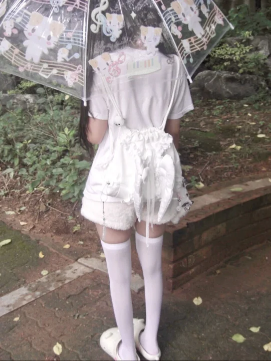 傘をさす女性の後ろ姿