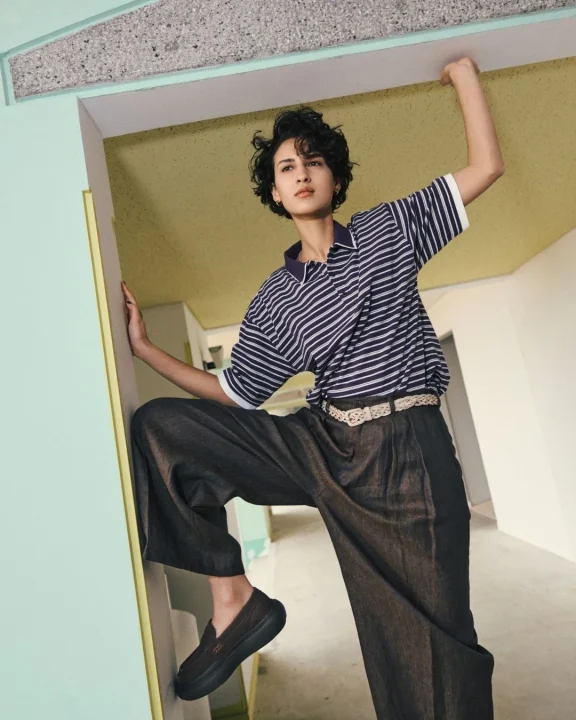 ストライプポロシャツとワイドパンツの女性