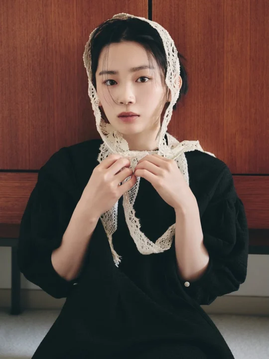 黒い服を着て白いレースのボンネットを被った若い女性