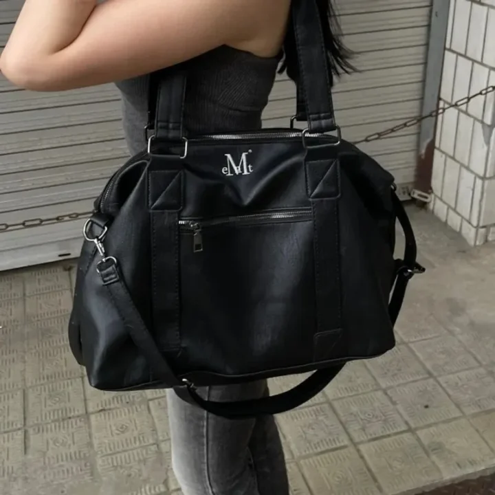 eMtのロゴが入った黒いバッグを肩にかけた人物