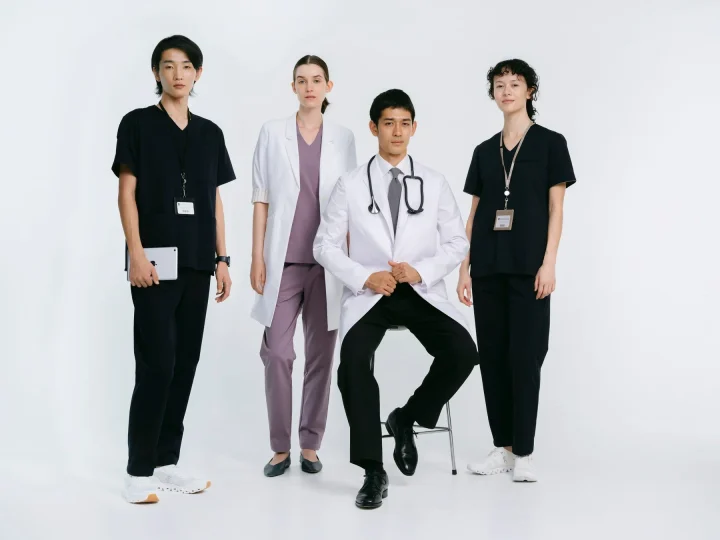 医療従事者たちが様々なユニフォームを着用してポーズをとる
