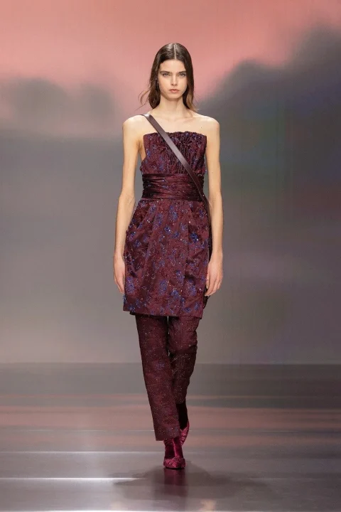 ワインレッドのトップスと柄物パンツ