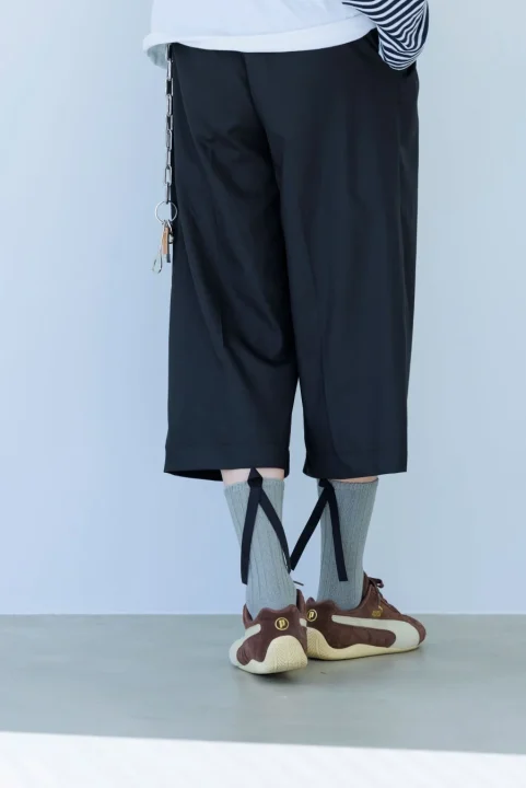 グレーのリブソックスとブラウンのスニーカー、黒のワイドパンツ