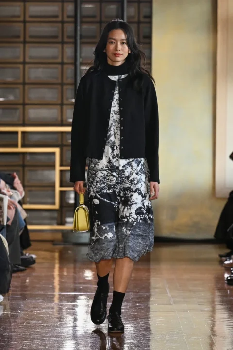 黒いカーディガンと白黒の花柄ドレスを着用したアジア人モデル。