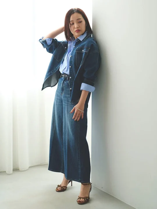 デニムジャケットとワイドデニムパンツを着用した女性