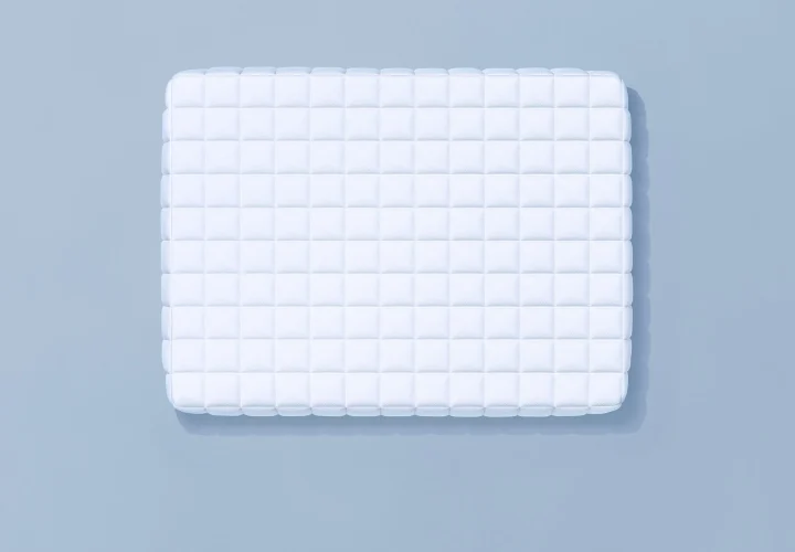 水色の背景に、白いキルティング加工された長方形のクッションまたはマットレスが置かれています。清潔感のあるシンプルなデザインで、柔らかそうな質感が特徴です。