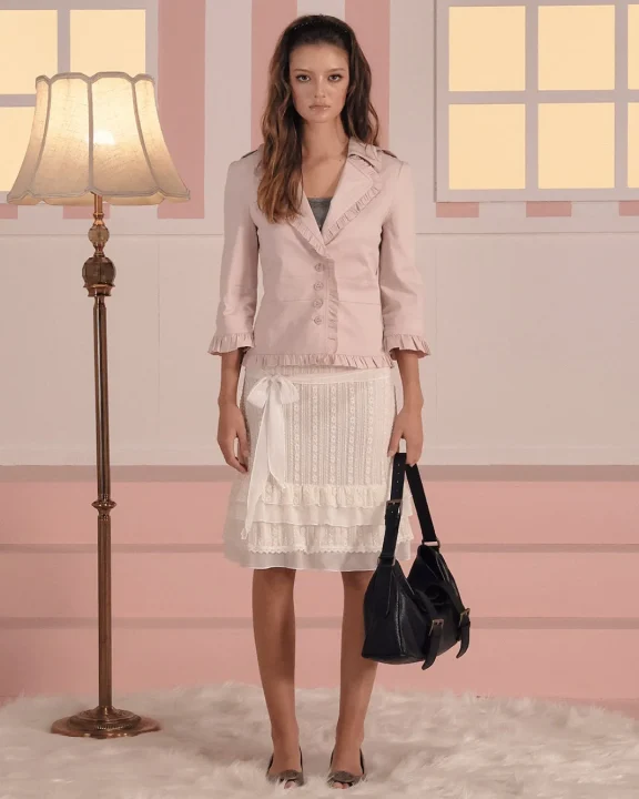 ピンクのフリル付きジャケットと白いレーススカートを着用した女性モデル