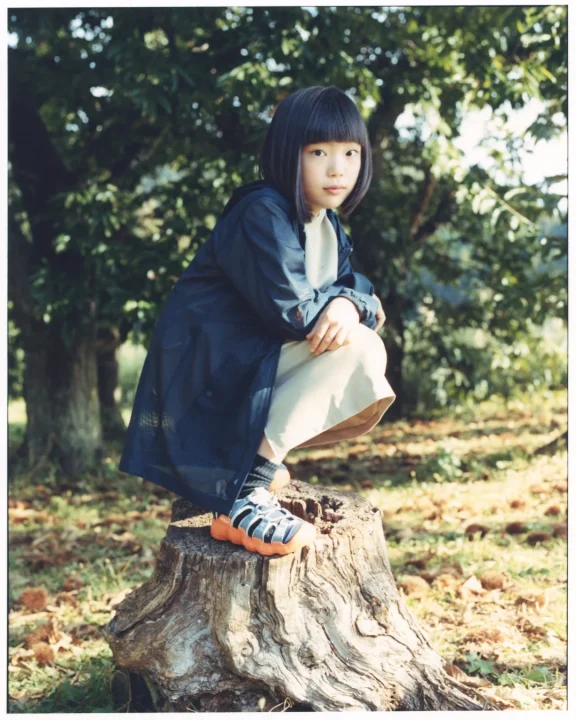 切り株にしゃがみ込む女の子