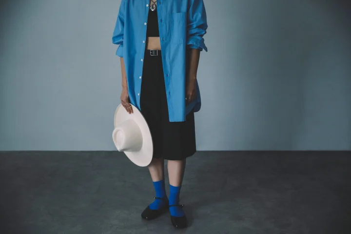 青いオーバーサイズシャツと黒いスカートのカジュアルなコーディネート