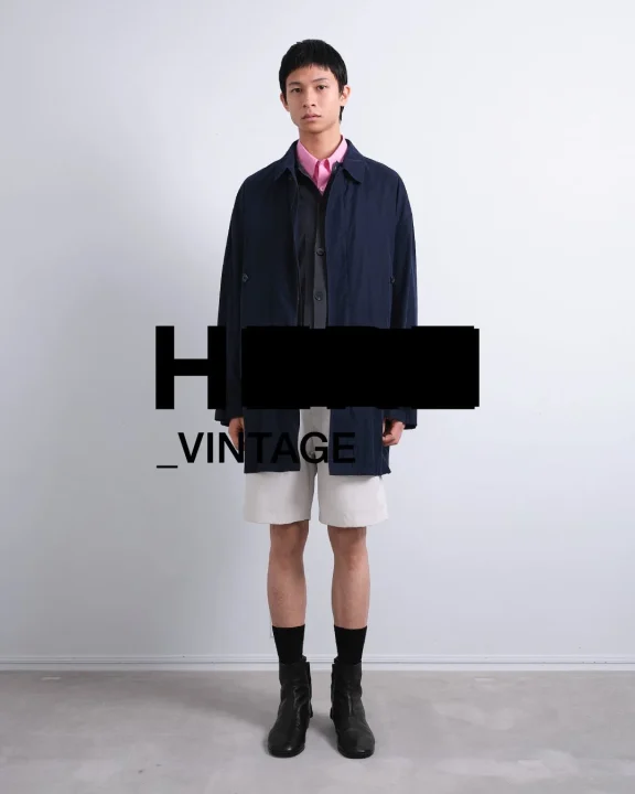 ネイビーのジャケットとピンクシャツを合わせた男性モデル