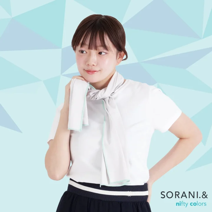 白いTシャツとスカートを着用した若い女性が、首にライトグレーのクールタオルを巻いています。