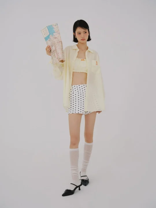 地図とドット柄スカートの女性