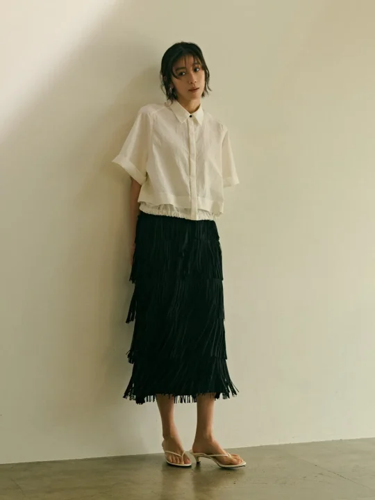 白シャツとフリンジスカートを着こなす女性
