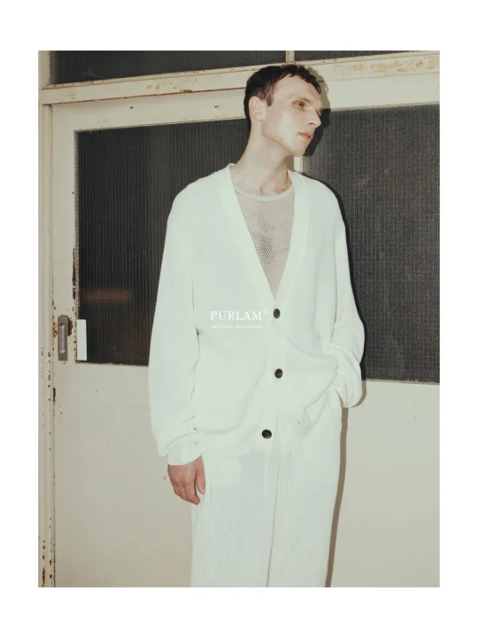 白いニットカーディガンとパンツを着た男性モデル