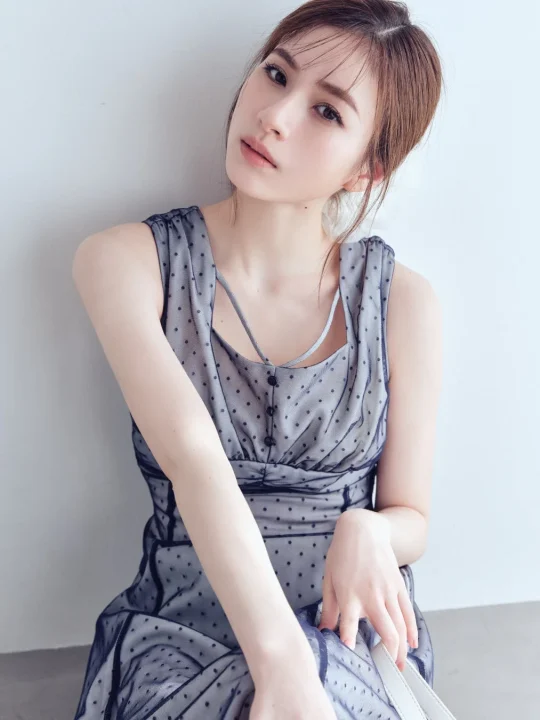 ドット柄のシースルー素材のグレーのドレスを着た若い女性