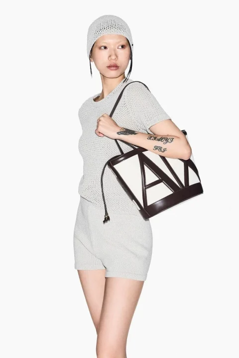 幾何学的なデザインのバッグを肩にかける女性