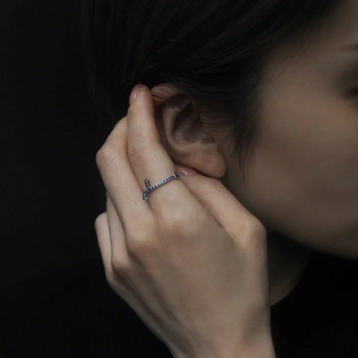 青い石のリングを着用した手