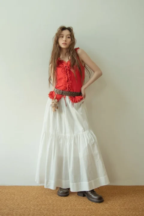 赤色フリルトップスと白スカート