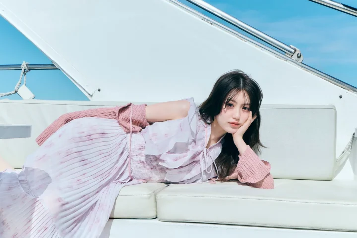 ヨットの白いソファに横たわる若い女性