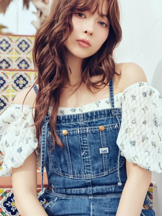 デニムオーバーオールと花柄ブラウスの階段ショット