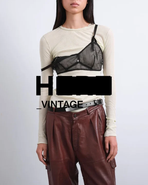 シアー素材トップスとレザーカーゴパンツを着用したモデル