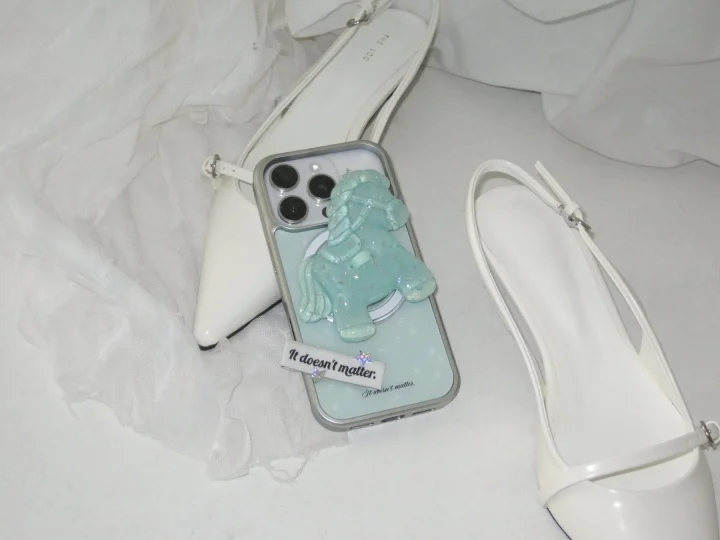 白いパンプスと馬のチャームが付いたスマートフォンケース