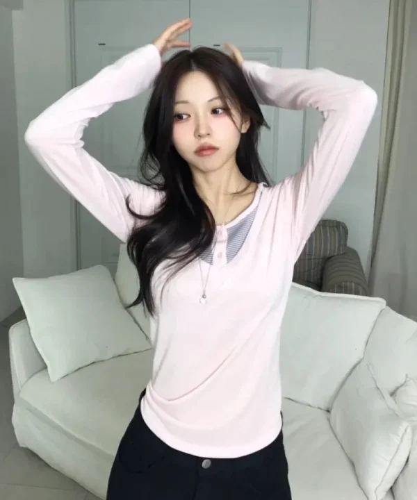 ピンクの長袖トップスと黒パンツのコーディネート