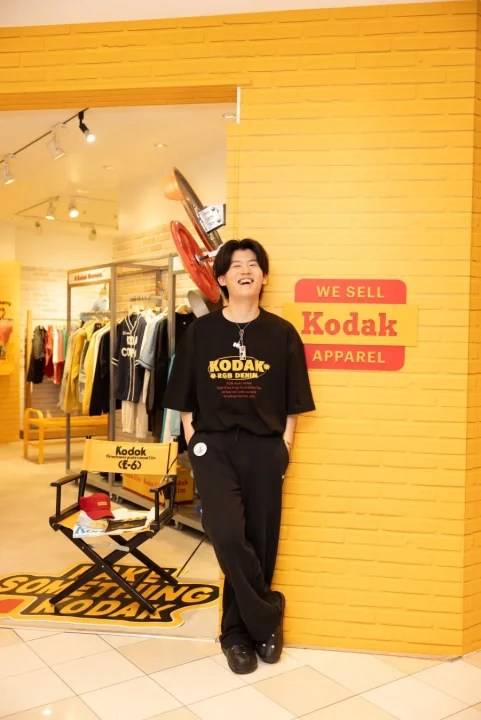 男性がKodakアパレルを着用し笑顔で立つ