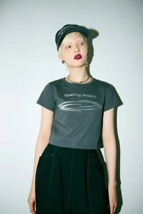 Opening Projectコラボ ロゴプリントTシャツを着用した女性モデル（ダークグレー）