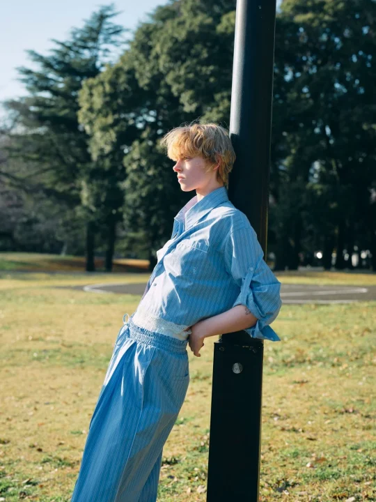 青いストライプの服を着た金髪の人物