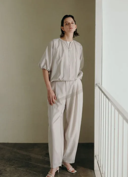 淡いベージュのセットアップを着用した女性。上品かつリラックス感のある大人のカジュアルスタイル。