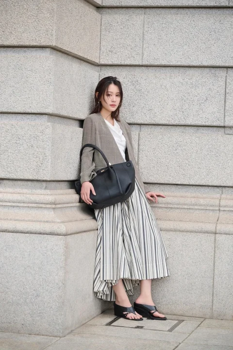 グレーのジャケットとストライプスカート