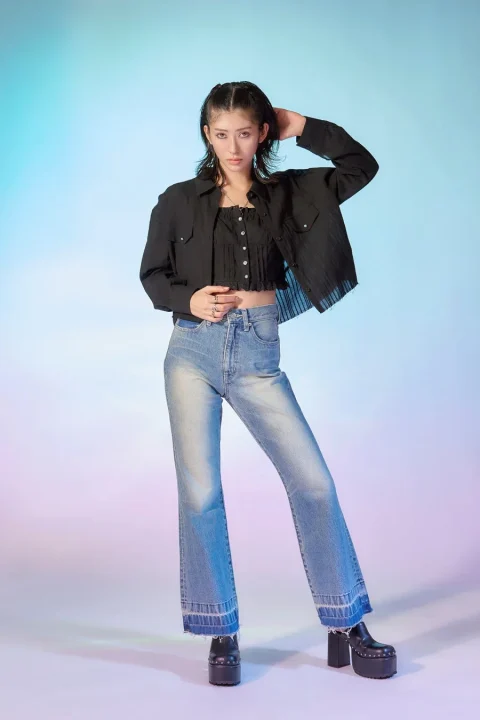 黒クロップトップとフレアジーンズの女性