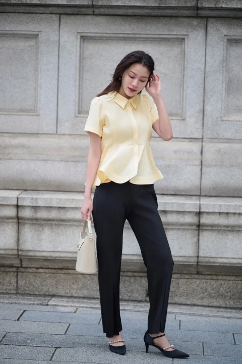 黄色ペプラムブラウスと黒パンツ