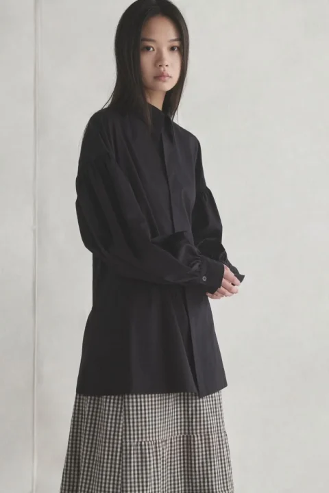 黒シャツとギンガムチェックロングスカートを着用した女性モデル