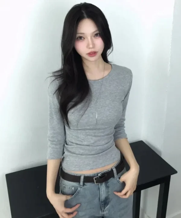 グレーの長袖トップスとライトブルーのジーンズのコーディネート