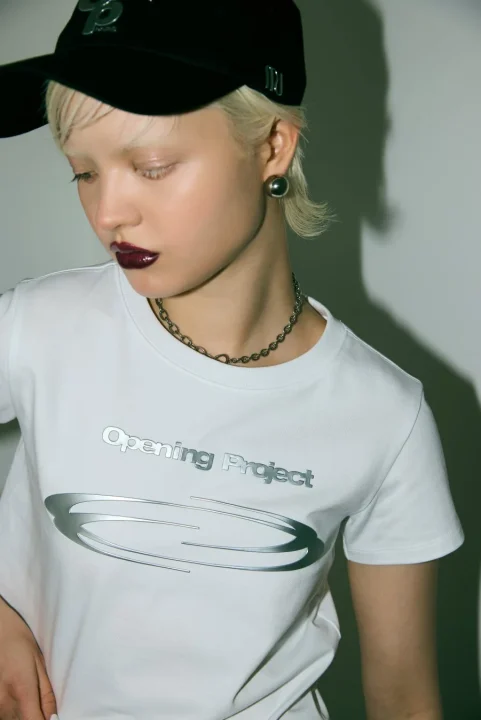 Opening Projectコラボ ロゴプリントTシャツを着用した女性モデル（白）