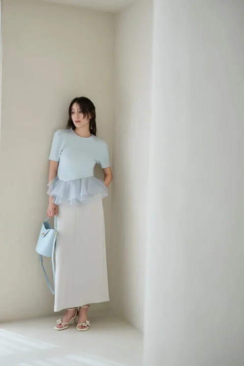 淡いブルーペプラムトップスと白スカート