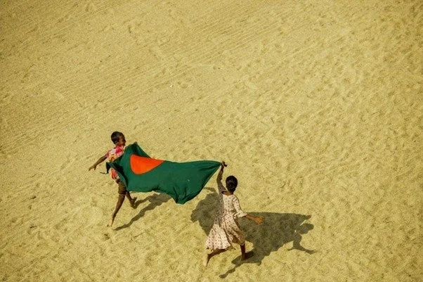 バングラデシュの国旗を持って走る子供たち