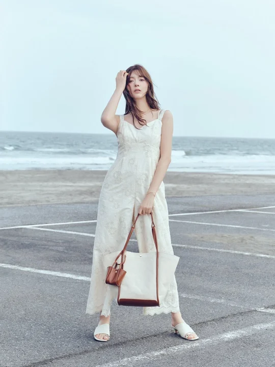 白いレースのオールインワンを着た女性の海辺ショット