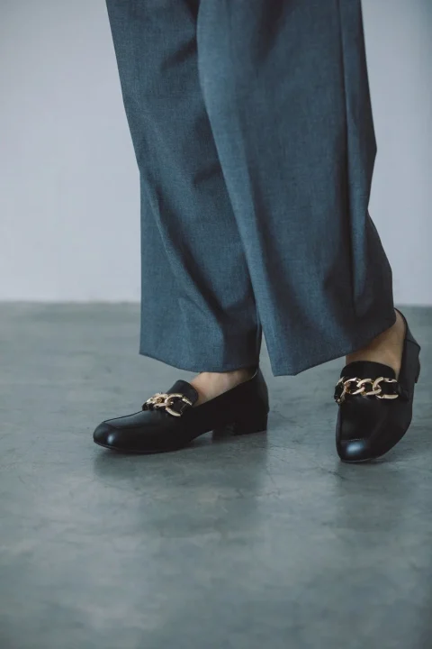 グレーのワイドパンツと黒いローファーの足元