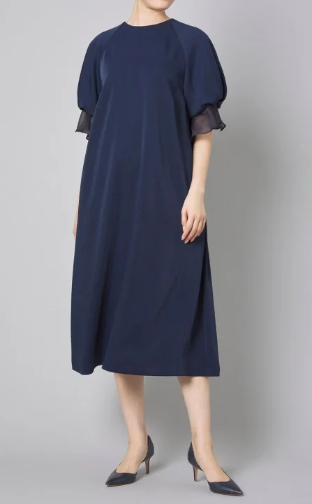 紺色のミディ丈ワンピースを着用した女性の全身写真です。