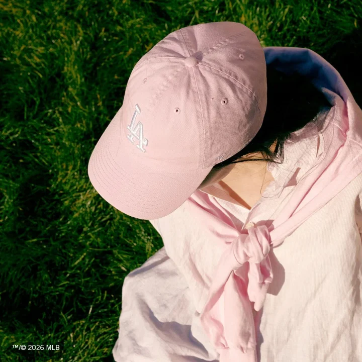 ピンクのLAロゴキャップの女性