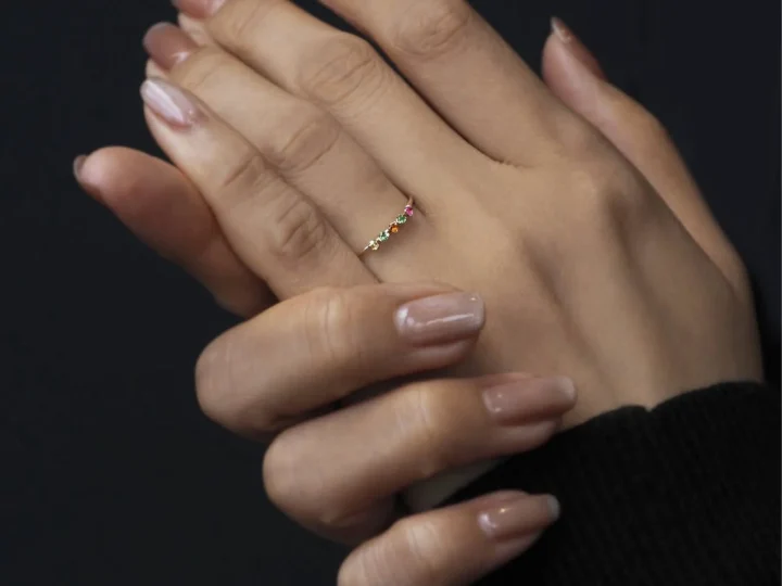 カラフルな宝石のリングを着用した手