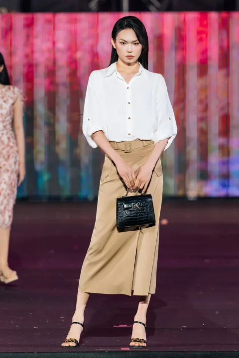 白いシャツとベージュのロングスカートを着用したモデル