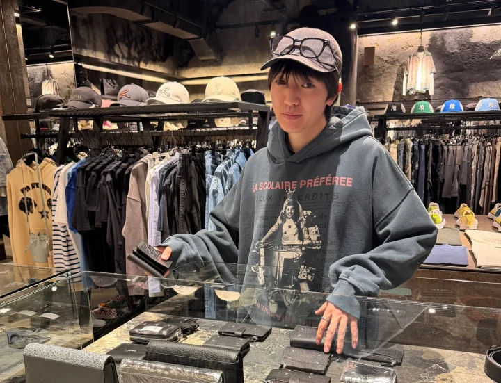 服屋で財布を見る男性