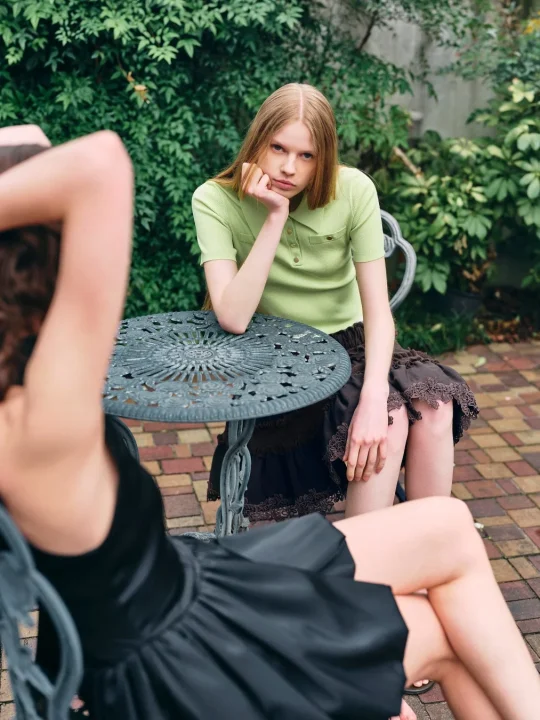 緑色のポロシャツとスカートを着用した女性