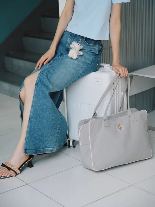 キャリーケースに座る女性